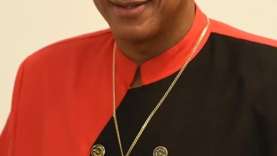 Portrait of Joel Davis in a black hat and red and black jacket