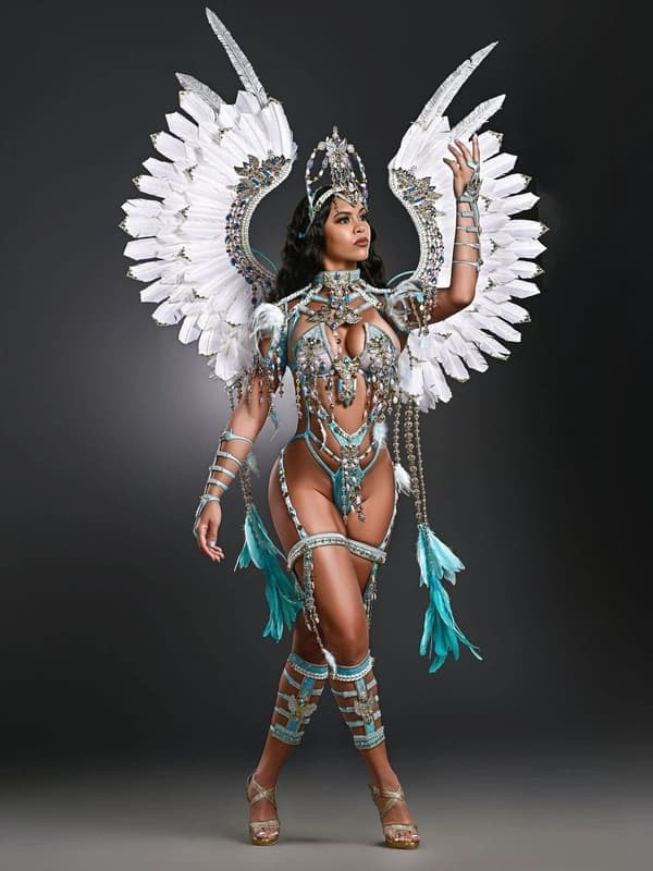 Model in a white and silver costume with tall feathered wings and a crown headpiece