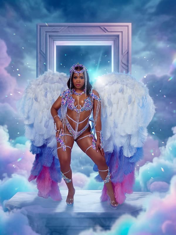 Halo costume: a model in white and blue feathers in front of a doorway in the clouds