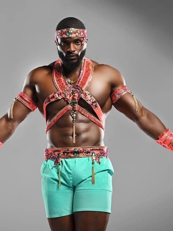 A man in a red and turquoise costume with a beaded harness and headband